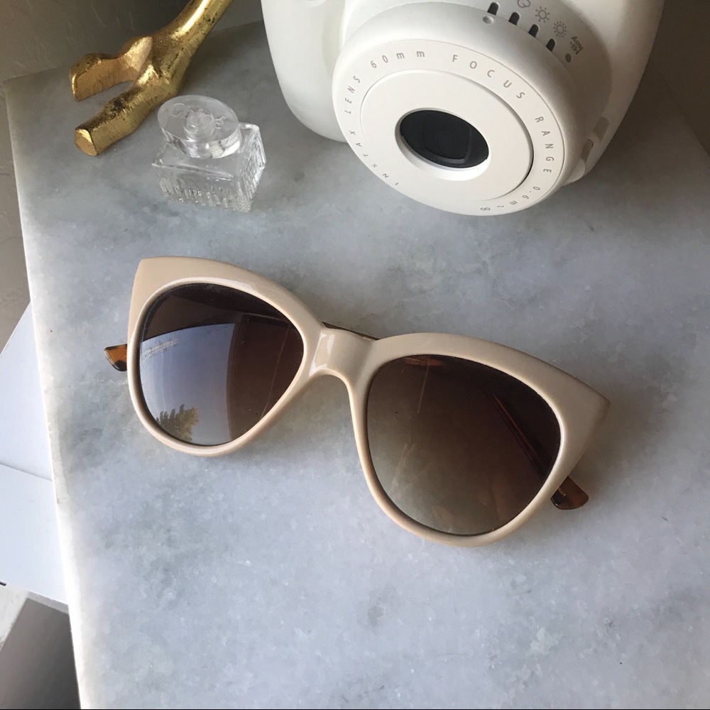 Beige sunglasses with leopard print arms.